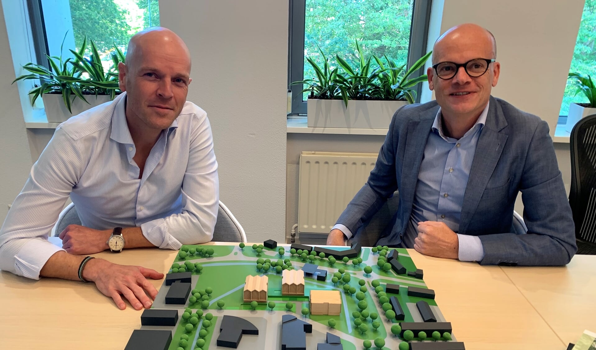 Myron Jacobs van Domus en François Claessens van Eemland Wonen achter de maquette met de drie woongebouwen. 