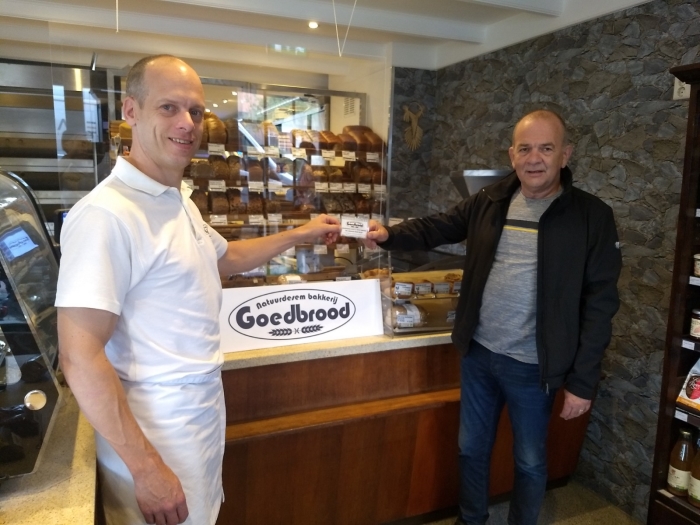 De heer Van der Wal neemt de waardebon ter waarde van € 50,- in ontvangst van bakker Roel van Bakkerij Goedbrood.