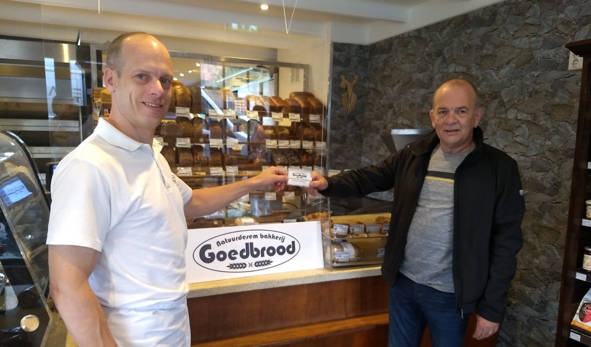 De heer Van der Wal neemt de waardebon ter waarde van € 50,- in ontvangst van bakker Roel van Bakkerij Goedbrood.
