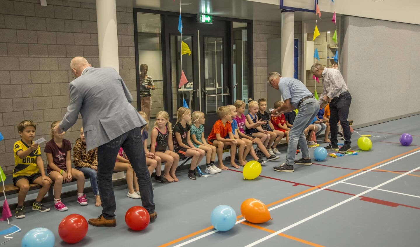 Ad van der Aa (VV Peursum), Ben Klieverik (Vridos) en Wim van Krugten (TilGroep) delen de bonnen in de nieuwe Giessenhal uit aan de kinderen.
