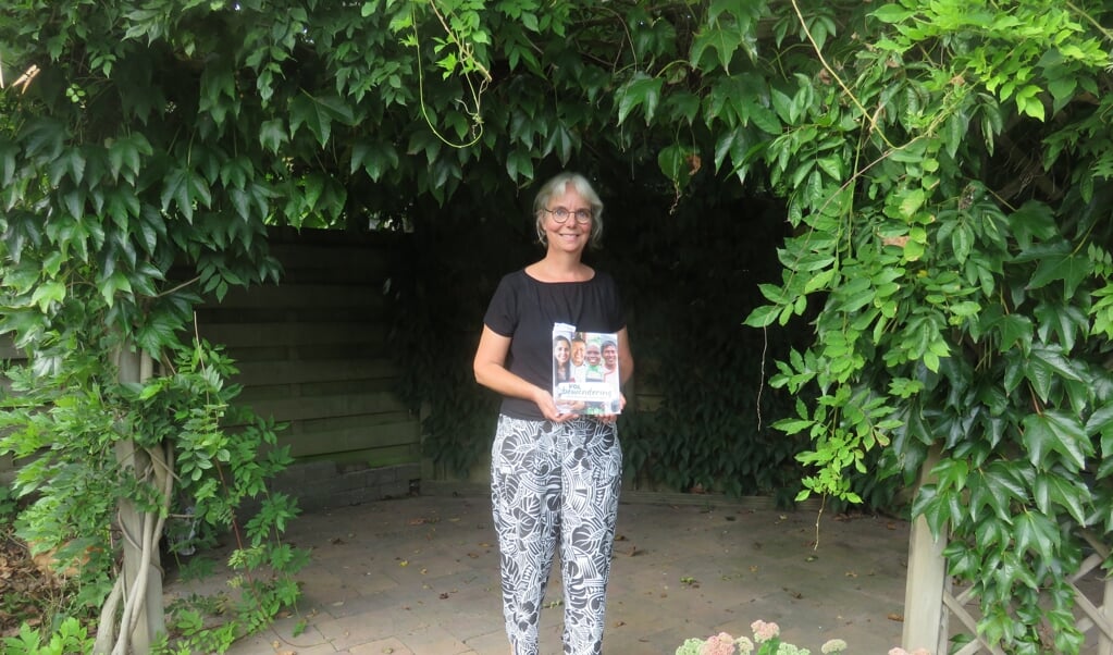Anne Stoppels met het boek 'Vol bewondering' waar drie verhalen van haar hand in staan