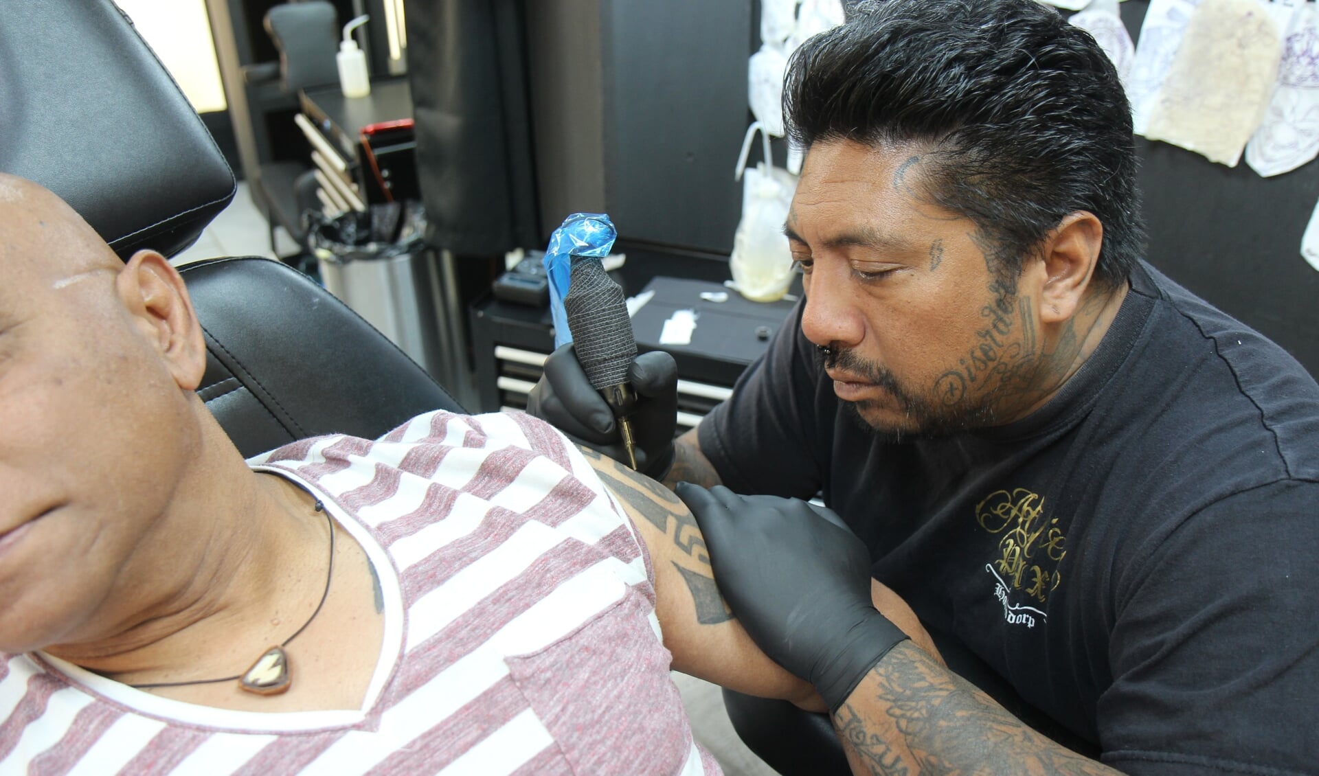 Steve Mahakena aan het werk, hij is een bekende in de wereld van de tatoeëerders.  