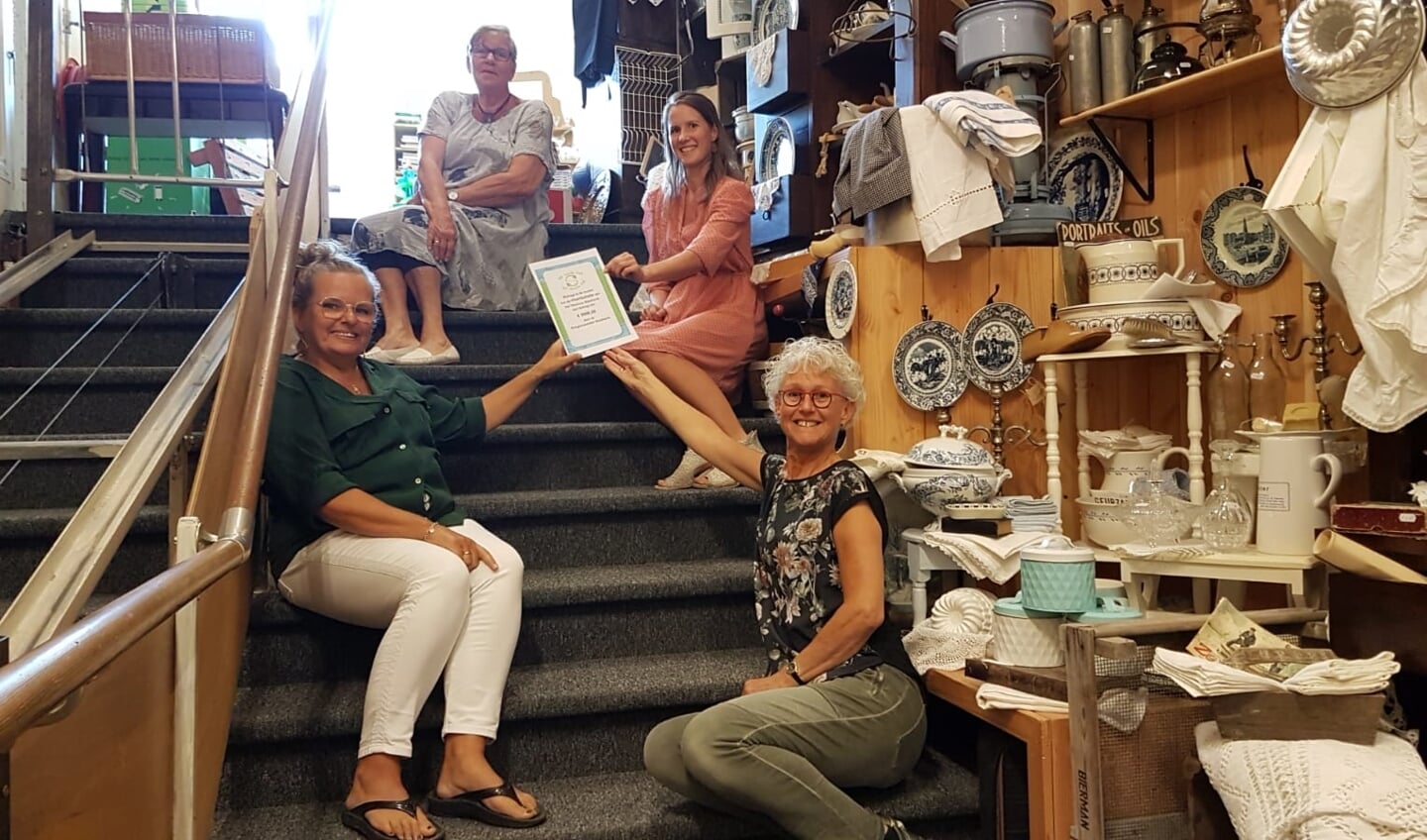 Willemsen en Van der Vlist overhandigen cheque van Kringloopwinkel aan Diana en Judith van het Timohuis. Het betreft 5000 euro voor de vloerisolatie.