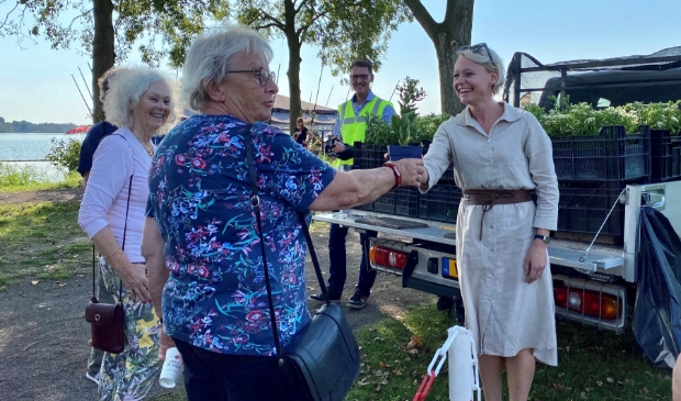 <p>Wethouder Floor Gordon deelt de eerste planten uit.</p>