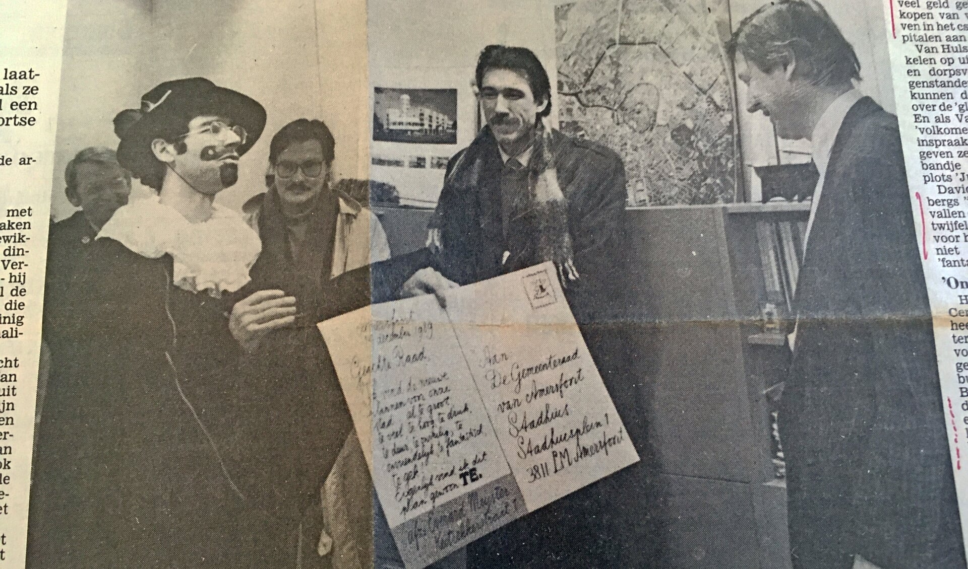 Strijders van het eerste uur tegen het Centrumplan, Daan van Hulst (links verkleed als Everard Meyster) en At Ypenburg, (in het midden) bieden wethouder Fons Asselbergs een bezwaarschrift aan. (De Amersfoortse Courant 10 januari 1990).