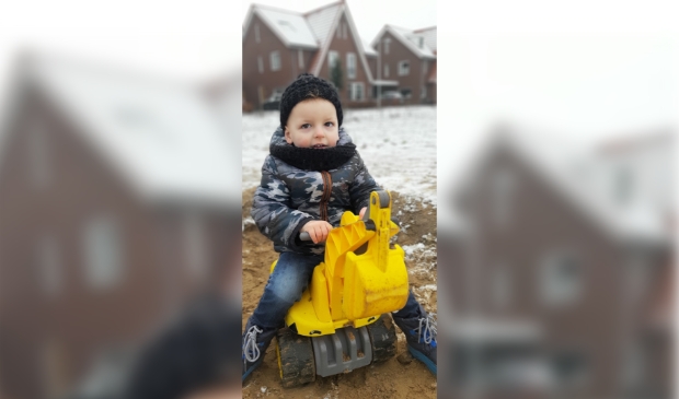 Jesse de Rooij (2 jaar) op graafmachine voor het huis in Kernhem