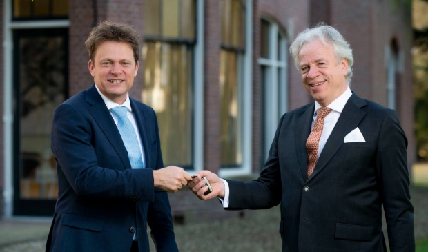 <p>Joop Iriks (rechts) draagt het stokje over aan Joan Janssens (links).</p>