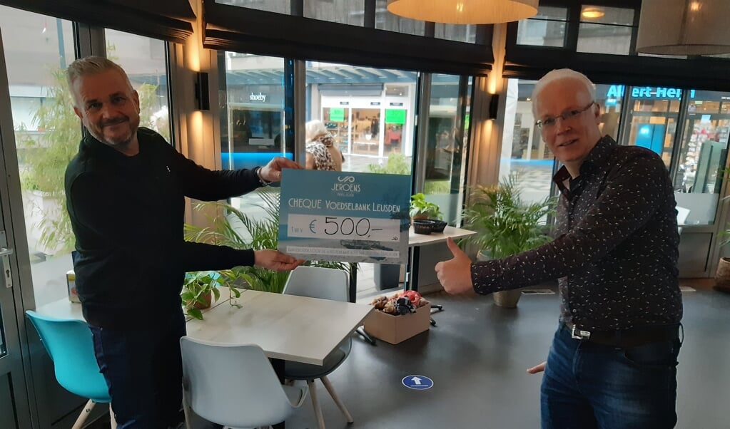 Jeroen Dammers (links) van Jeroens Paviljoen overhandigt de cheque van 500,= euro aan penningmeester Henk Krakers van de Voedselbank.