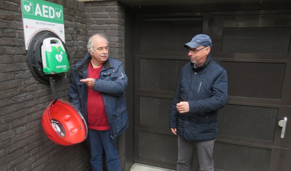 Richard Postma (l) toont de nieuwe AED aan Paul van der Horst.