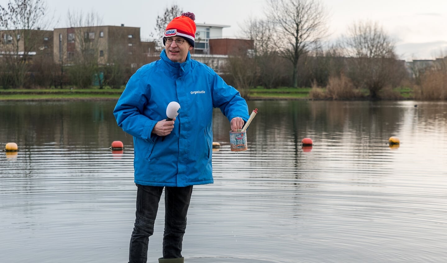 Voorzitter Eric de Groot meet traditioneel de watertemperatuur in de Rietplas, in het blik. 