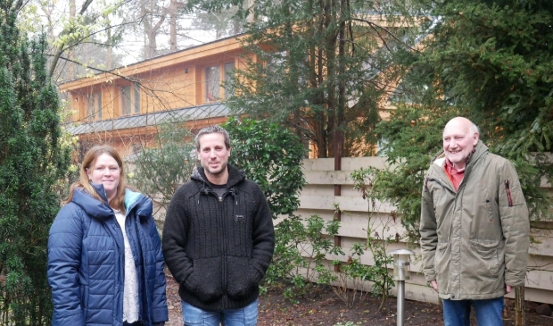 V.l.n.r.: Karin, Mike en Dago in de achtertuin met op de achtergrond het bijgebouw dat al groter is dan hun woningen.