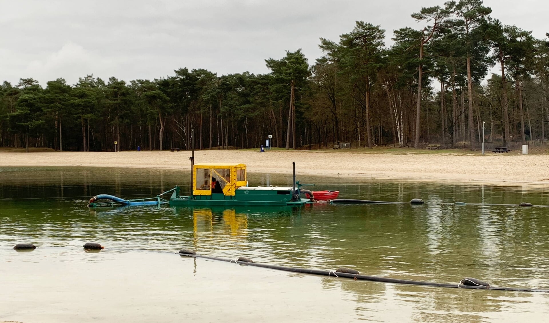 Het verwijderen van het sliblaagje en de waterplanten van de bodem van het Henschotermeer gebeurt vanuit een bootje met behulp van een pijpleiding 