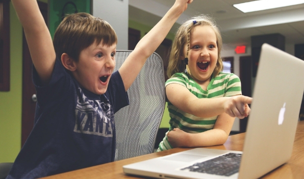 Juichende kinderen achter een laptop