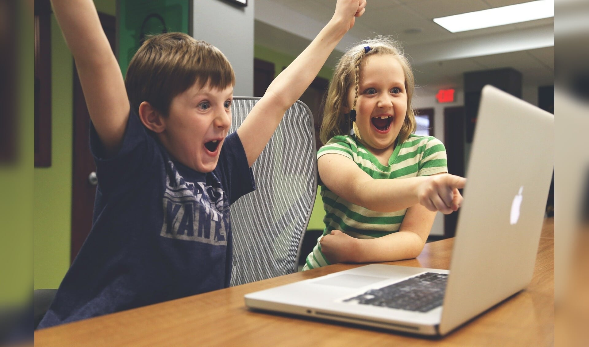 Juichende kinderen achter een laptop