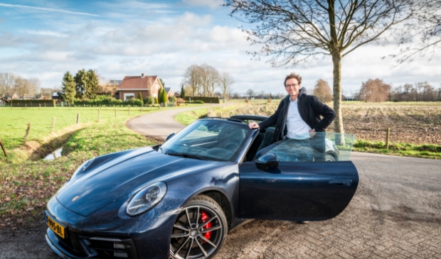 <p>Carl Koetsier op de foto met de exclusieve auto van een klant.</p>