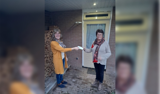 Wanda Westeneng overhandigt het statiebonnengeld aan Geryjanne Wiedijk van de Voedselbank