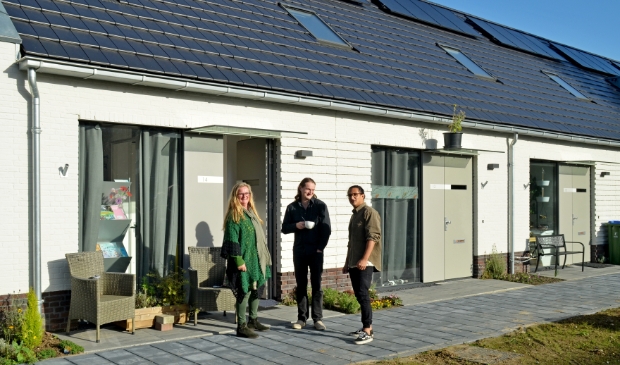 <p>Karin, Jelle en Dylan voor de witte woningen: "Hier in het Groene Hofje valt voor iedereen alles op zijn plek!"</p>