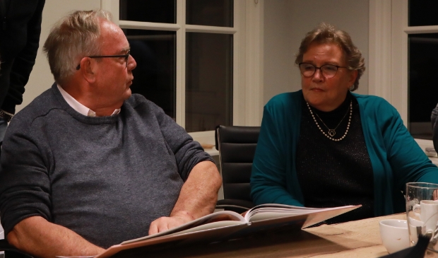 Karel Schneider bekijkt met zijn vrouw het fotoboek