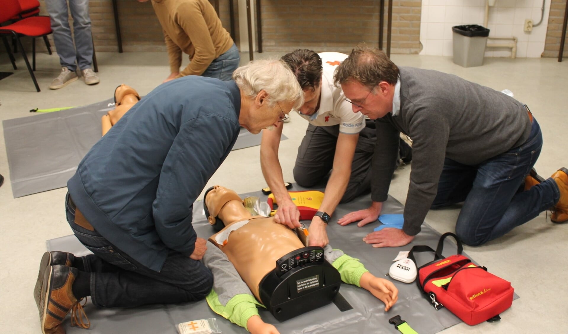 Instructeur geeft uitleg AED