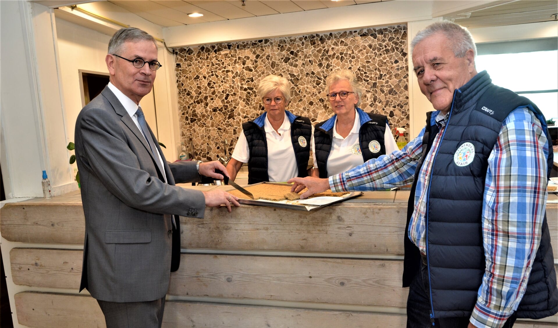 Wethouder Marco Verloop sneed de Veenendaalse Bierborselkoek aan tijdens zijn bezoek.