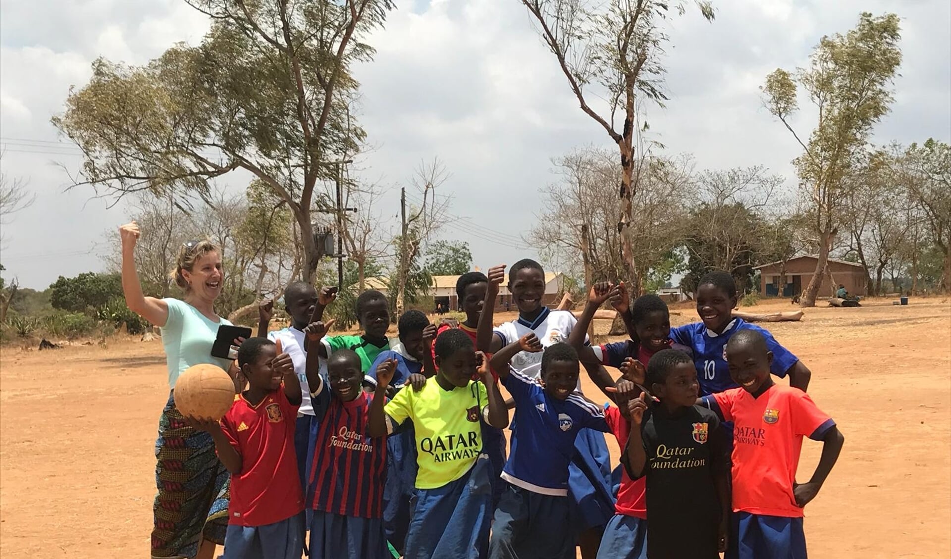 Annette de Leede (links op foto) in Malawi met kinderen die dolblij waren met voetbalshirts