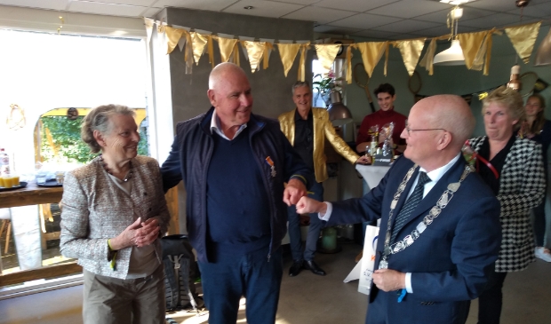<p>Henk Pruijssers ontvangt de onderscheiding uit handen van burgemeester Ruud van Bennekom, in aanwezigheid van zijn vrouw</p>