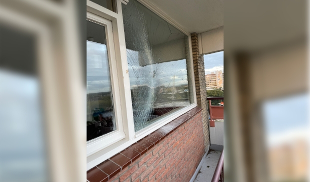 De schade aan het raam van de woning op elf hoog, veroorzaakt door een bouwkraan.