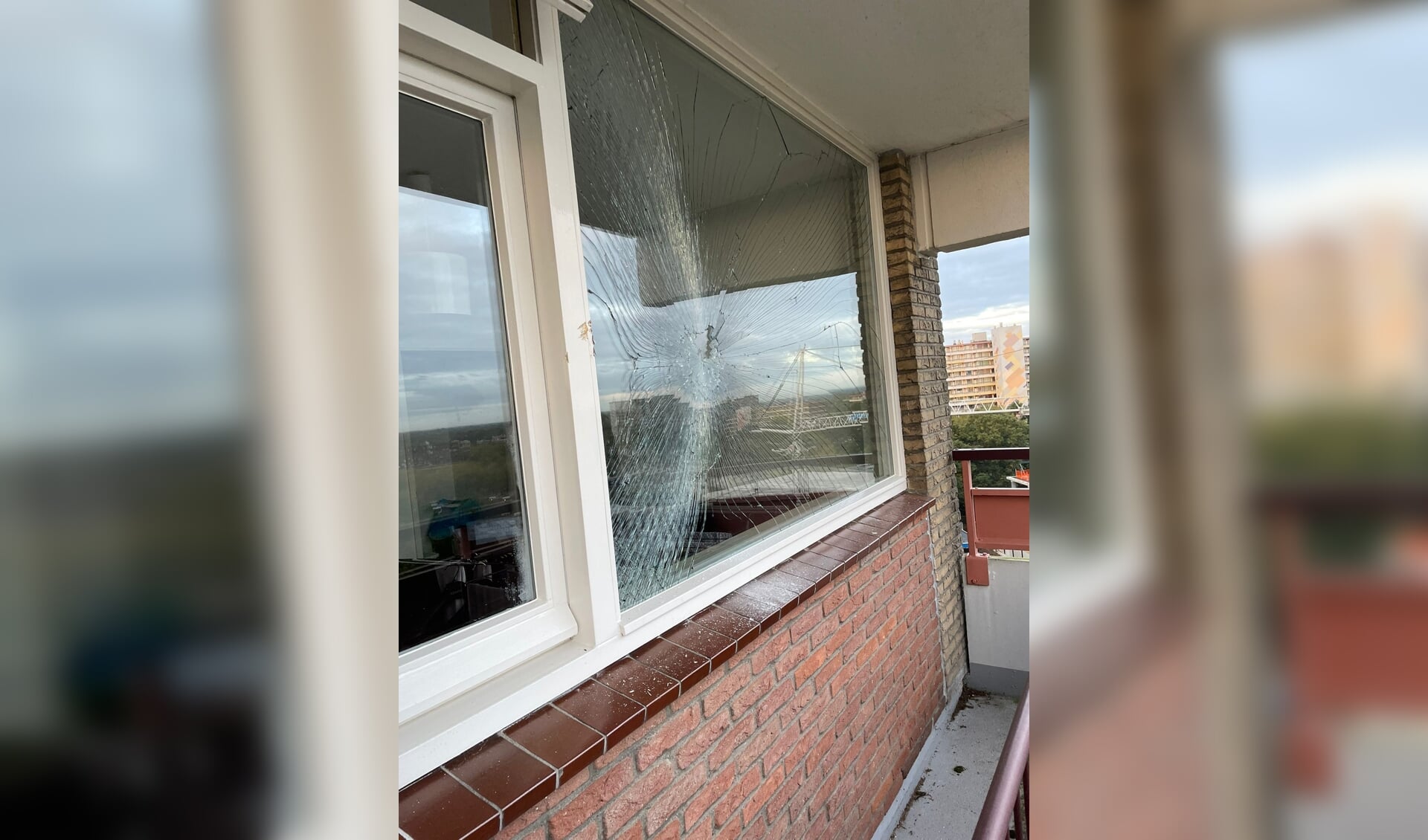 De schade aan het raam van de woning op elf hoog, veroorzaakt door een bouwkraan.