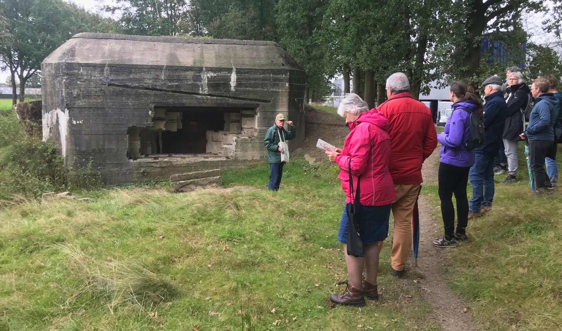 De gids legt de hoedanigheden van de Duitse bunker R703 uit aan een enthousiaste groep deelnemers aan de herdenkingstocht langs de oorlogsobjecten.