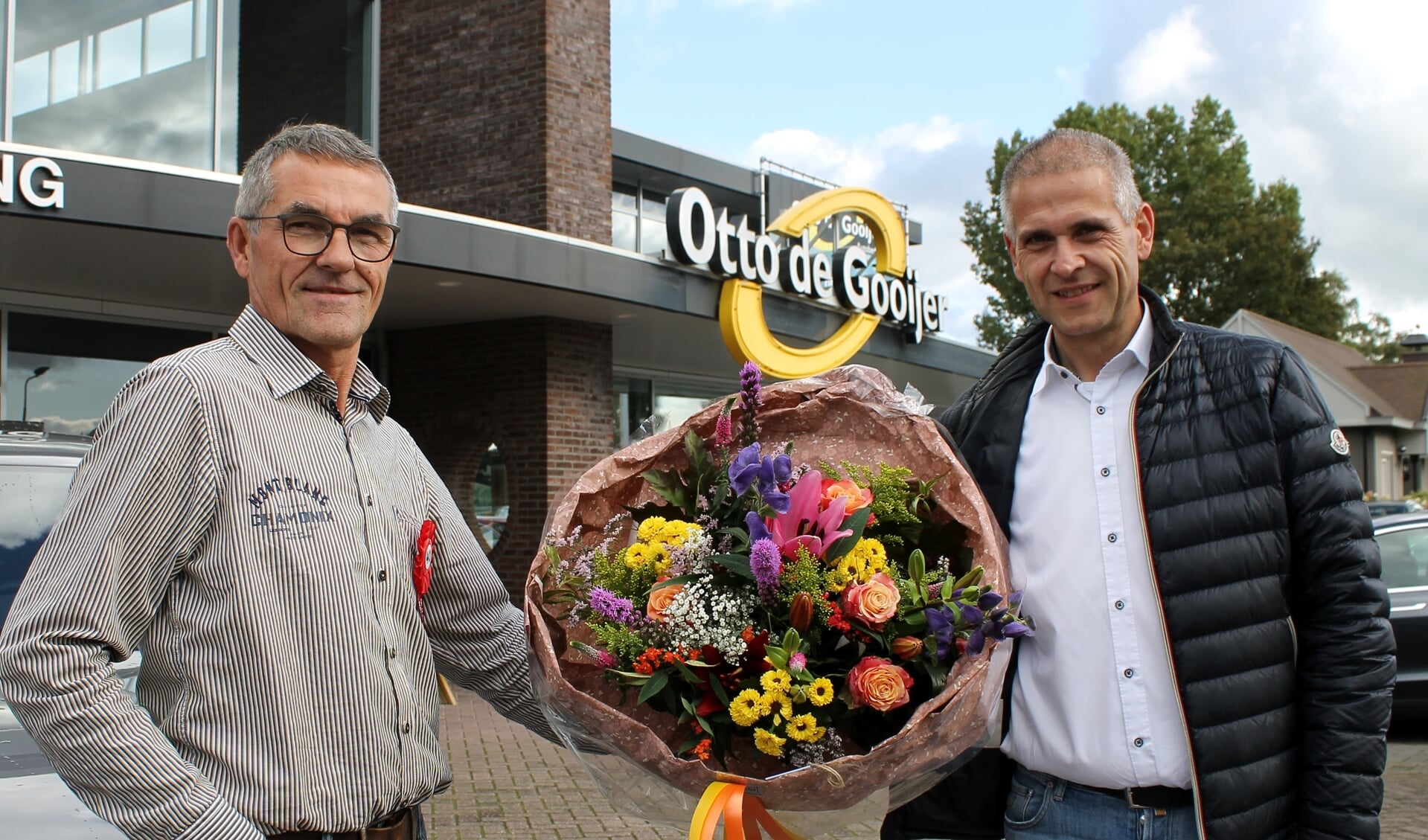 Jubilaris Jan van den Bos krijgt uit handen van Otto de Gooijer (l) een mooie bos bloemen ter gelegenheid van zijn 40-jarig werkjubileum