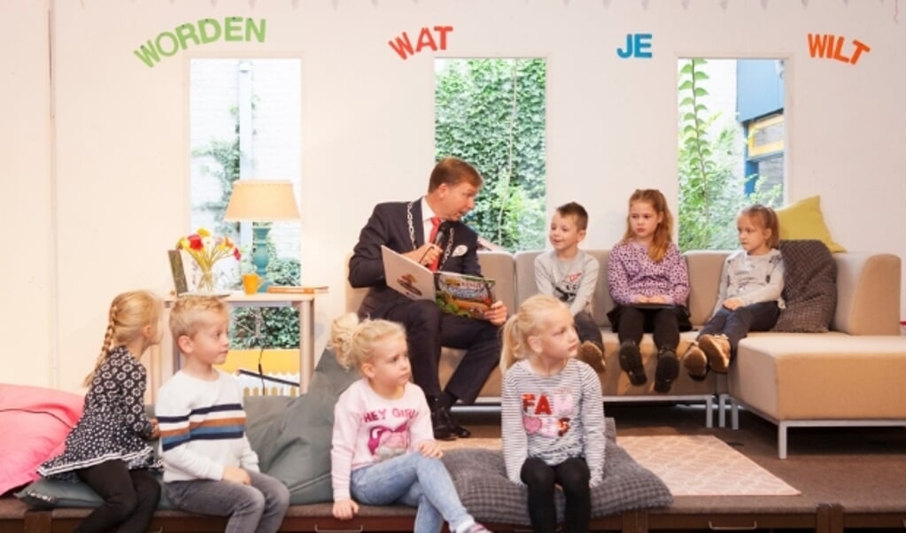 Burgemeester Kats leest het prentenboek voor: 'De GIGAgrote pompoen' aan de kinderen van De Schakel