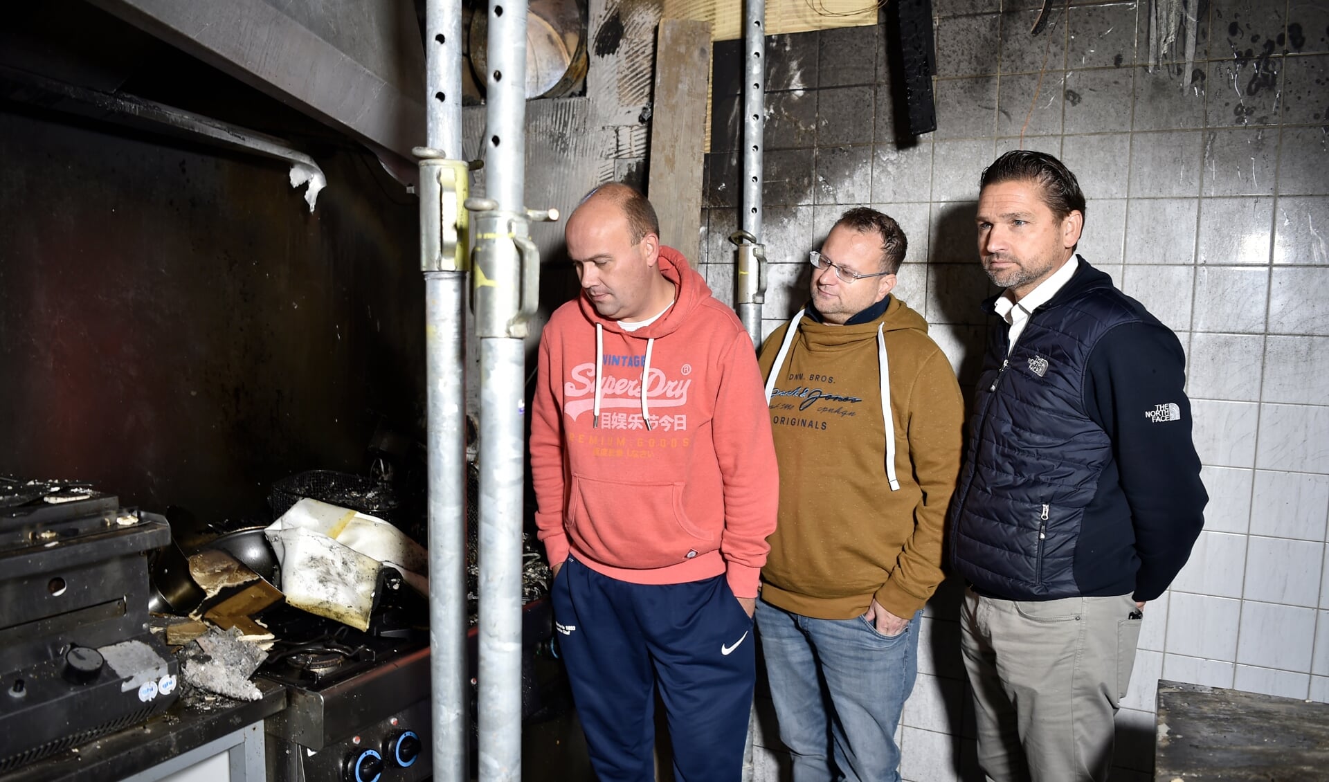 Arnoud Boer (links), Edwin Presser en Vincent van der Wardt nemen een kijkje in de keuken van d'Oude Enghe waar de brand begon.