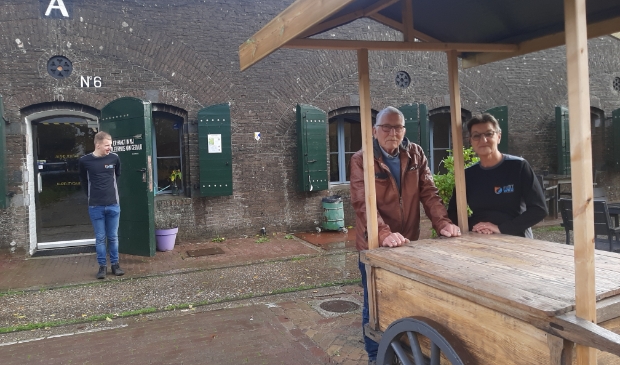 Piet en Rina bij hun kraam op het fort, op de achtergrond een deelnemer van Reinaerde