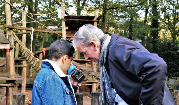 Burgemeester Hans van der Pas kijkt samen met kinderburgemeester Waled
op de app van de audiotour.