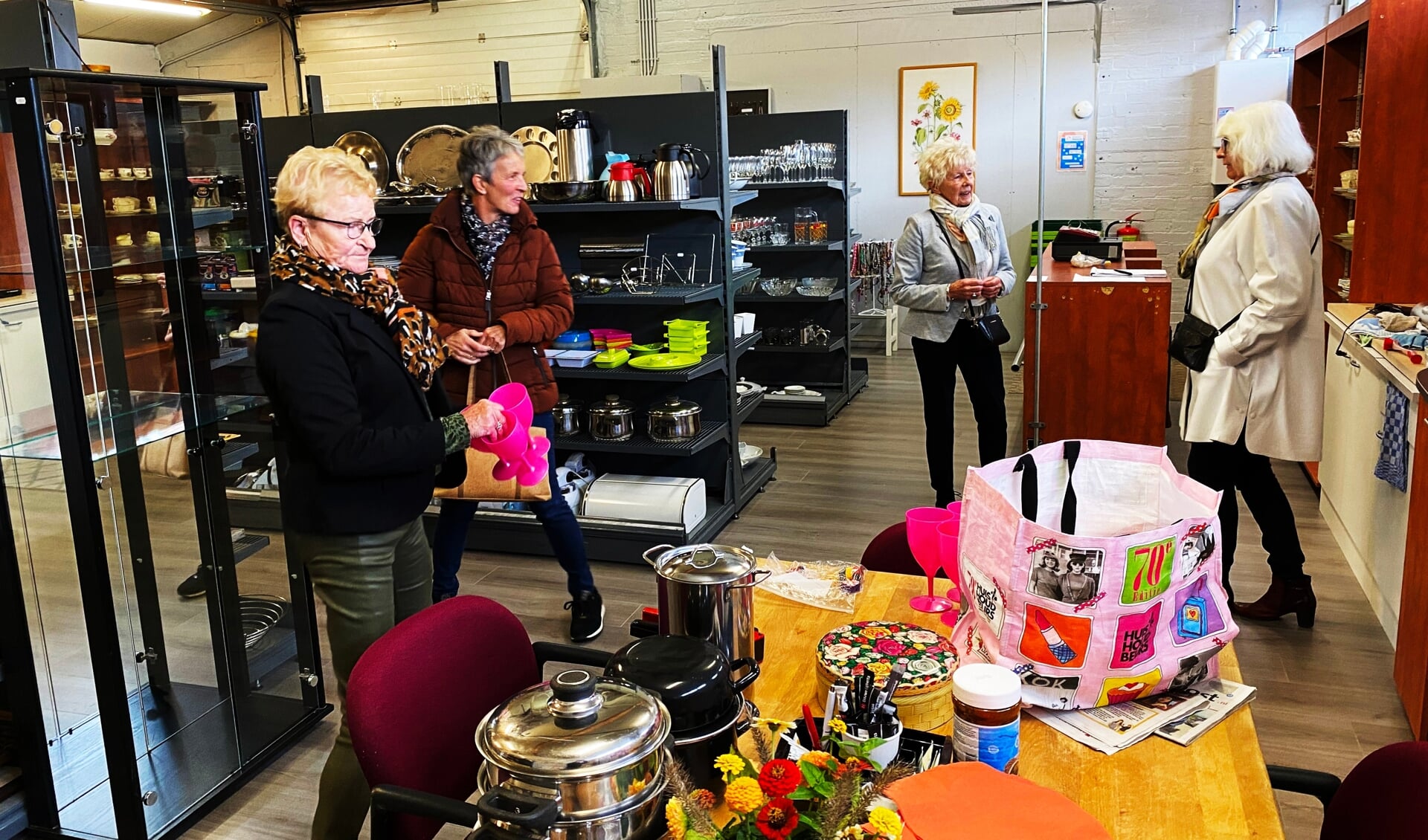 Ria van Zanten, tweede van links, in gesprek met enkele bezoekers van de nieuwe Kringloopwinkel.