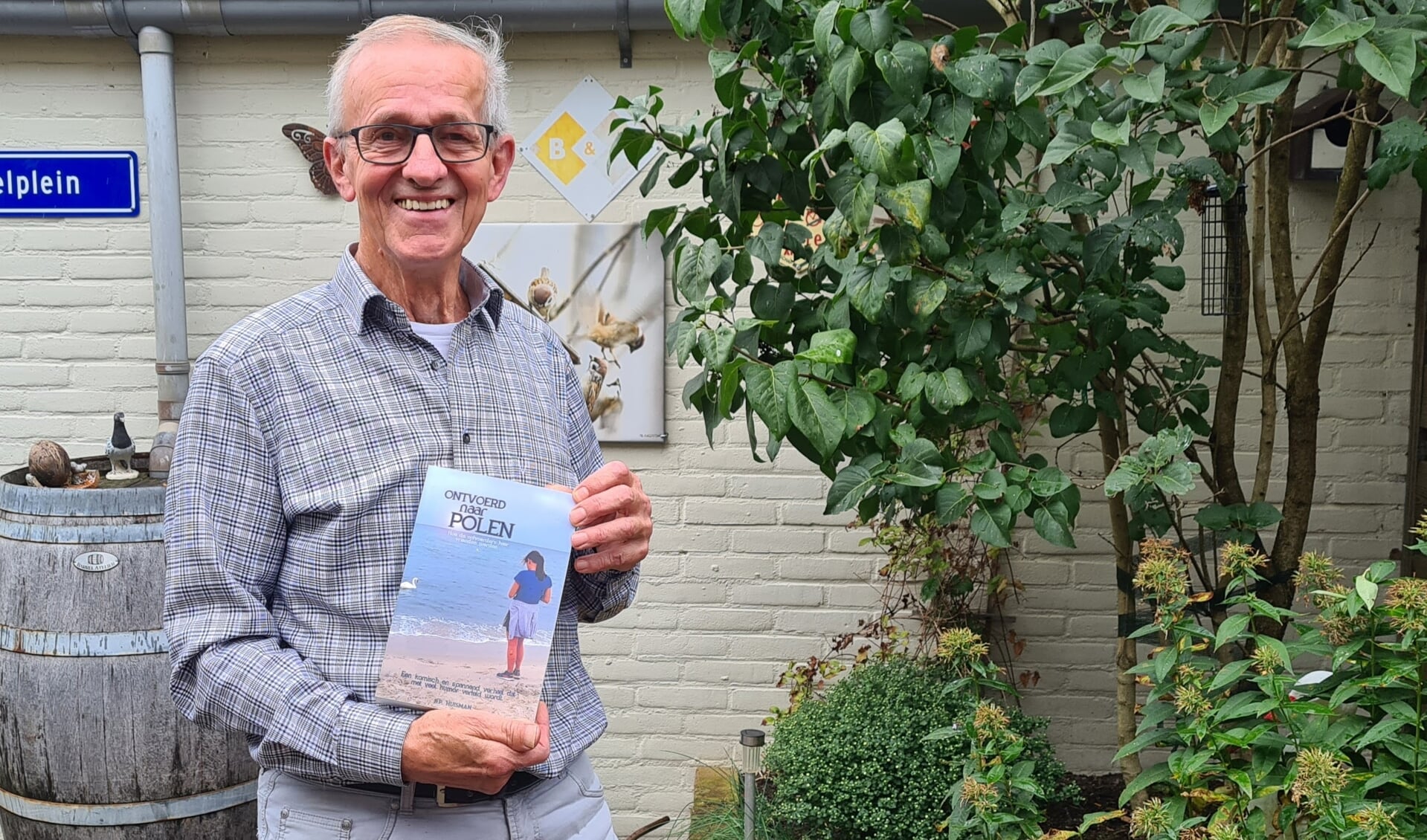 Blij en trots toont wandelende schrijver Bert Huisman zijn eerst verschenen boek.