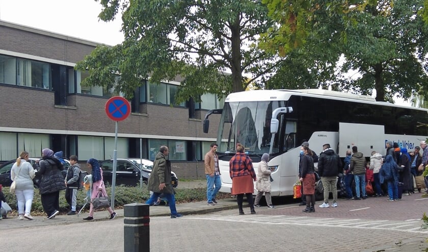 Bus met vluchtelingen voor noodopvang in voormalig belastingkantoor
