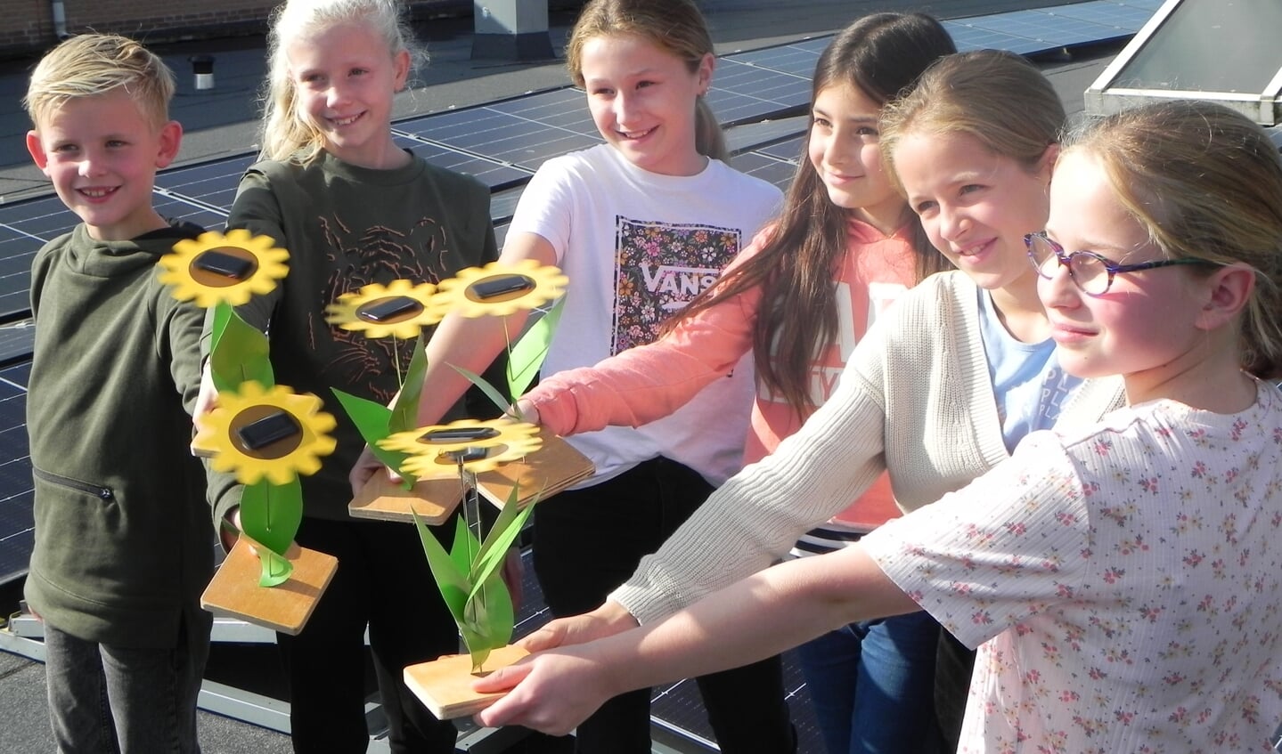Luca, Lynn, Marit, Sofie, Eka, en Sanne laten hun op zonne-energie opererende zonnebloemen draaien.