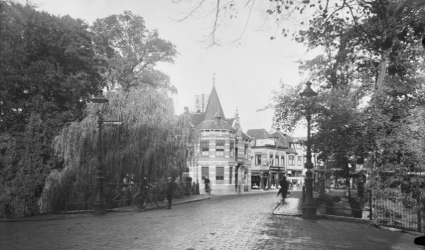 <p>De Utrechtseweg midden jaren &lsquo;20 richting de binnenstad, met een plantsoen en een brug. </p>