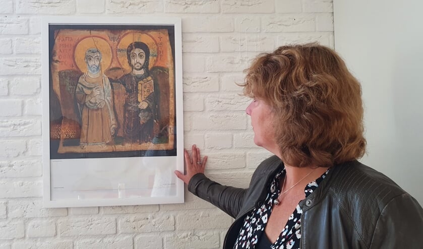 Rebecca Onderstal kijkend naar een kunstwerk dat altijd op de Lichtjesfiets staat en een hand op de schouder en luisterend oor uitbeeldt.