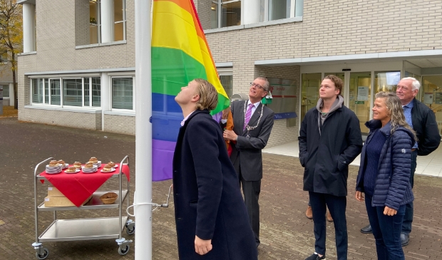 <p>Maarten, de zoon van Gerrit van der Meer, hijst de regenboogvlag. Burgemeester Gorter assisteert. De gebakjes (optimistjes!) staan al klaar</p>
