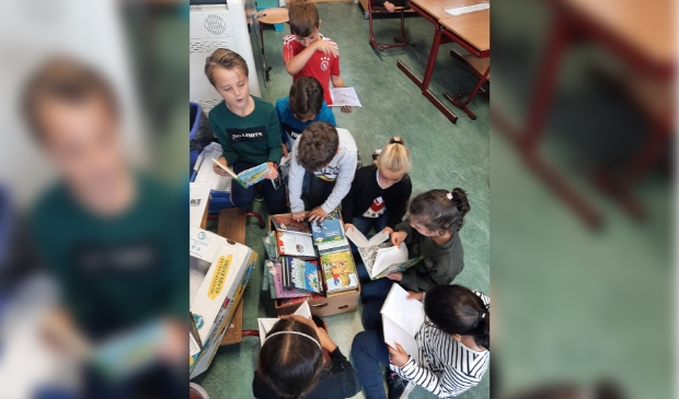 Groep 4/5 duikt de boeken in.