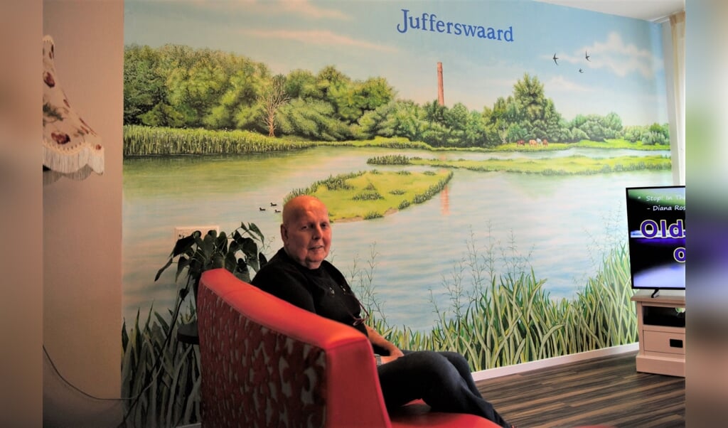 Wim Jansen bij zijn muurschildering ‘Jufferswaard’ in de recreatieruimte van Het Beekdal.