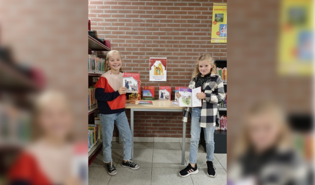 Liselot en Lise zijn blij met de nieuwe boeken voor de PWA-bieb!