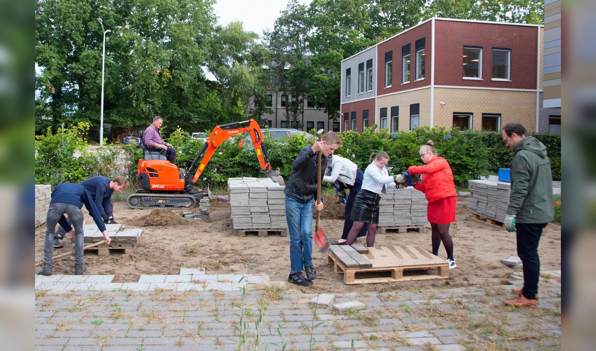 Kinderen, vrijwilligers en personeel werken samen aan de voorbereidingen voor de Schou-tenhoeve. Ton is actief op de kraan. 