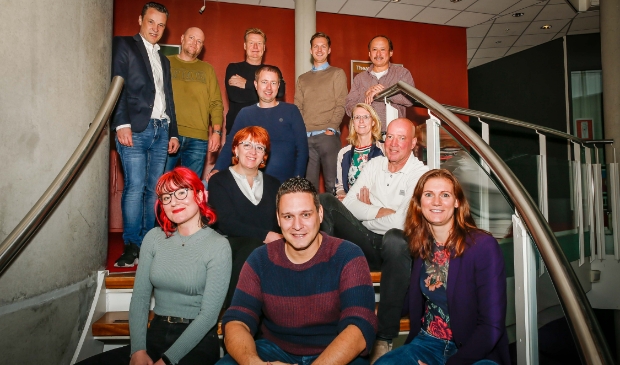 <p>Bovenste rij, van links naar rechts: Johan Mulder, Erik Spit, Dick van Laar, Christoph Willemsen en Martin Brink. Staand op de trap Sander van Snippenberg met voor de kijkers rechtsonder hem Ilse Bruinekreeft. Zitten in het midden Diana Kervel en Frans de Kleuver. Zittend op de voorste rij, van links naar rechts: Elyse van den Brink, Boy Imminck en Marieke van Egdom.</p>