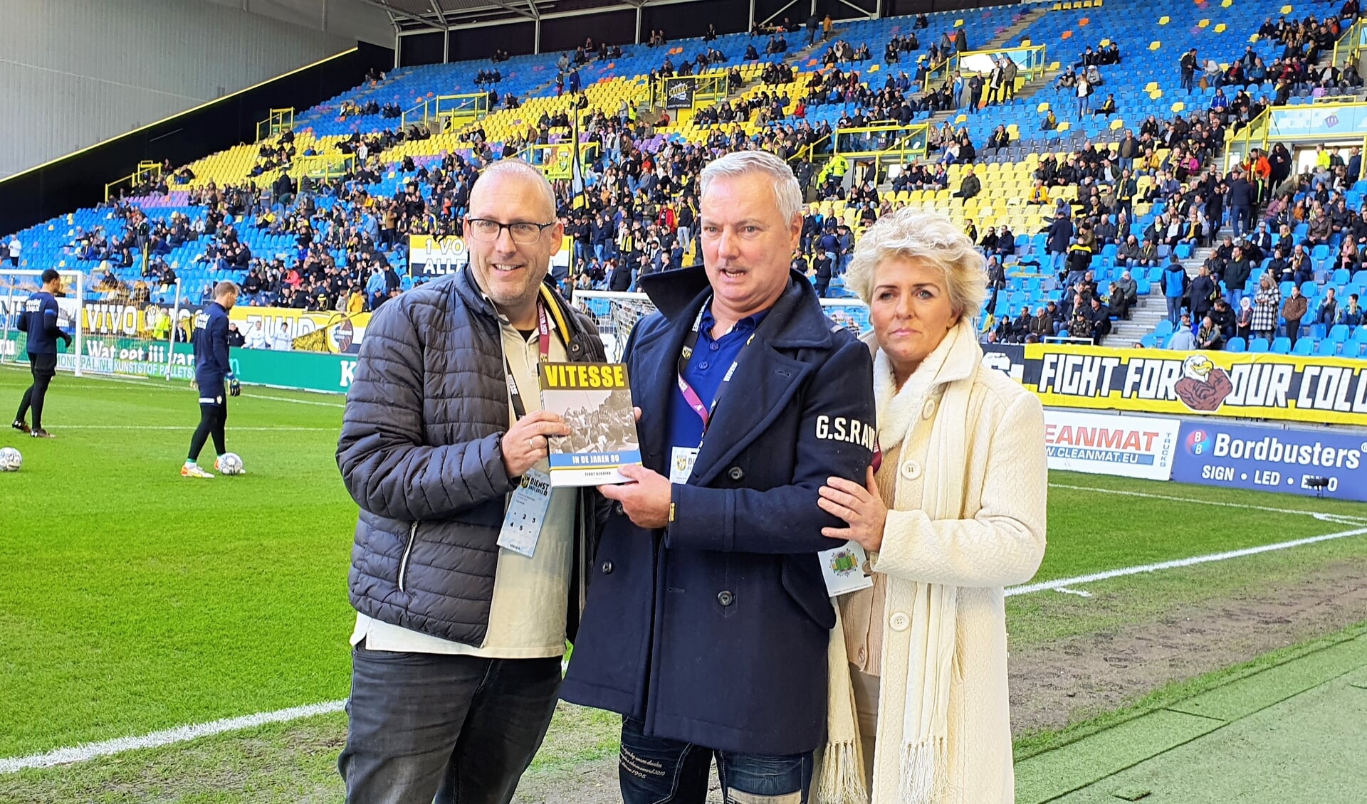 Auteur Ferry Reurink (links) overhandigt het eerste exemplaar van 'Vitesse in de jaren 80' aan Roel Smand en zijn echtgenote.
