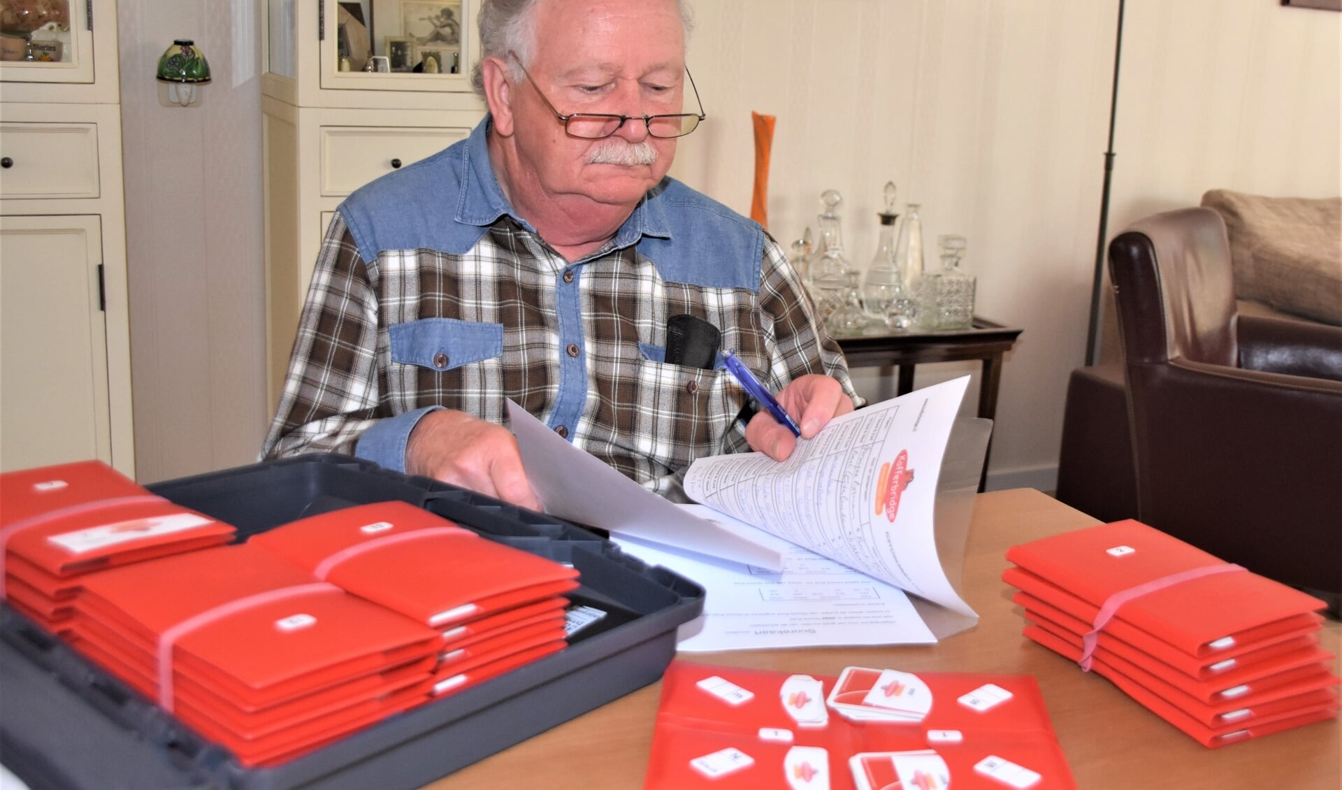 John van den Bremer is bezig met het klaarmaken van koffers.