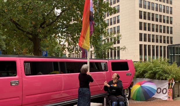 Ervaringsdeskundige Judith (rechts) en Ageeth Ouwehand hijsen de regenboogvlag.