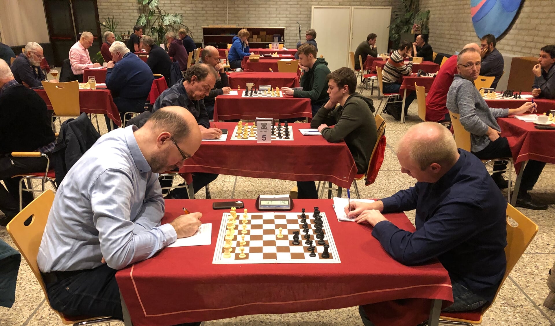 Jan Willem Kinkel (links), niet alleen een goede penningmeester maar ook schaker wint van Van den Brink. 